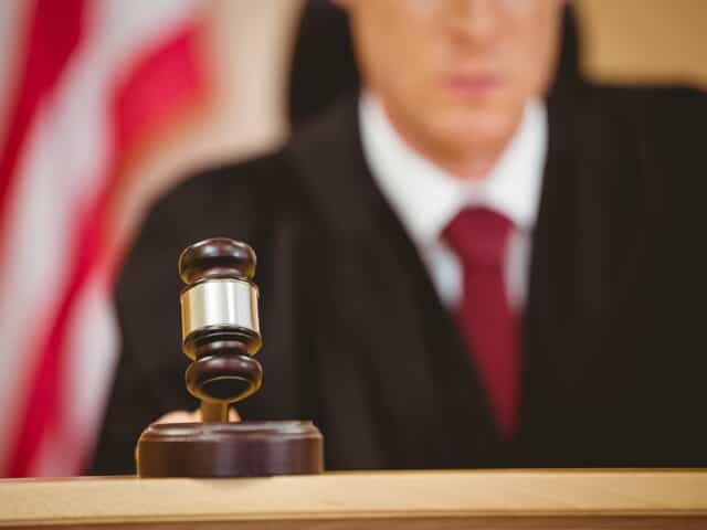 Judge in family law court with gavel and USA flag behind him